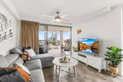 a living room with a couch and a tv at Spacious Inner city Apartment with free parking in Brisbane