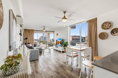 a living room with a couch and a table and chairs at Spacious Inner city Apartment with free parking in Brisbane