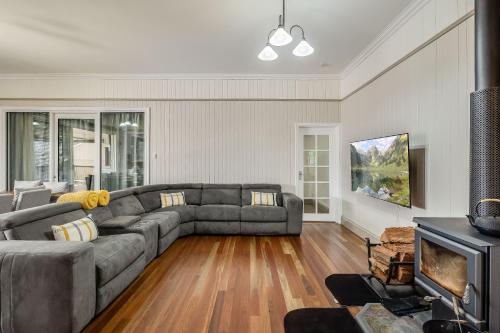 a living room with a couch and a television at Elegant, Stunning & Central! East Side Gem! in Toowoomba