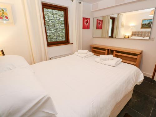 茅根海岸的住宿－White Lodge Apartment，一间卧室配有两张白色的床和镜子