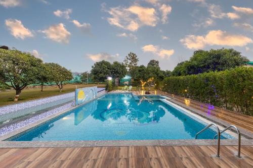a large swimming pool with a wooden deck at Seven Corbett in Rāmnagar