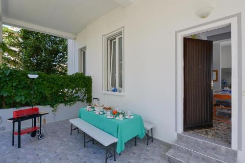 a table with a green table cloth on a patio at Your Dream on Lake Maggiore: Historic House e Private Jacuzzi in Stresa