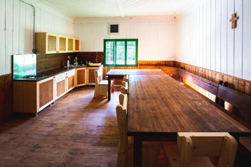 a kitchen with a long wooden table and benches at Chata POUSTEVNA ( Střelecká ) in Vrbno pod Pradědem