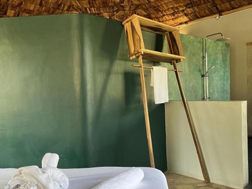 um quarto com uma parede verde e uma escada de madeira em The Jungle Pearl Resort em Mto wa Mbu