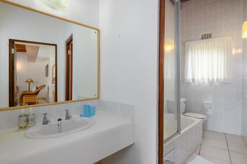 uma casa de banho com um lavatório, um espelho e um WC. em San Lameer Villa 2843 - 2 Bedroom Classic - 4 pax - San Lameer Rental Agency em Southbroom