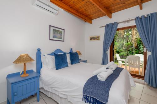 um quarto com uma cama azul e branca e uma janela em San Lameer Villa 2843 - 2 Bedroom Classic - 4 pax - San Lameer Rental Agency em Southbroom