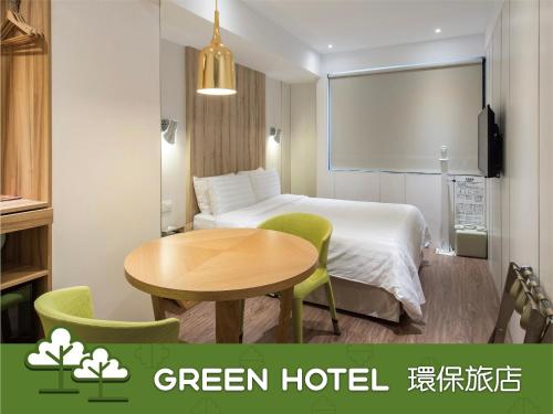 um quarto de hotel verde com uma mesa e uma cama em Hotel Relax II em Taipei