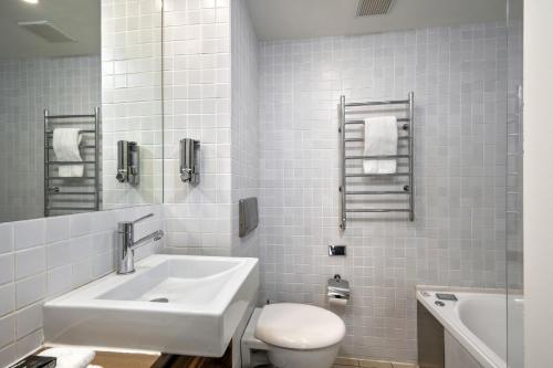 a white bathroom with a sink and a toilet at Lantern 17 Deluxe - Parking in Thredbo
