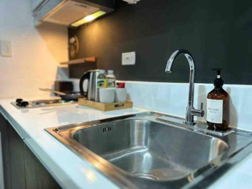 a kitchen sink with a soap bottle next to it at Modern Classic 1 BR Condo Air Residences Makati in Manila