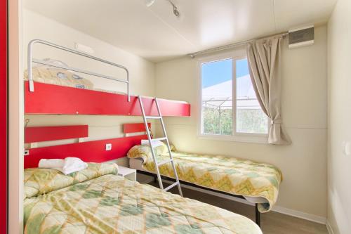 sypialnia z 2 łóżkami piętrowymi i oknem w obiekcie Camping Residence Oliva w Rabacu