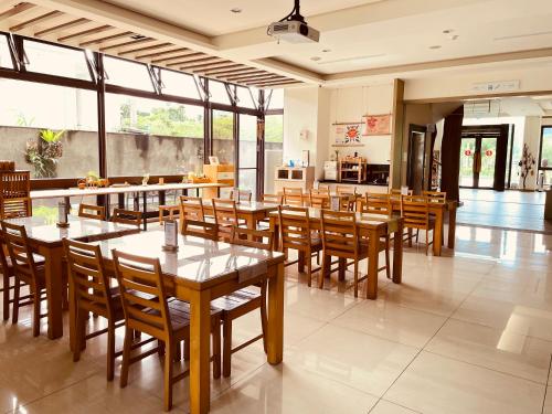 a restaurant with wooden tables and wooden chairs at 兩腳詩集綠活學旅 l 全自助入住平日旅館 l in Jiji