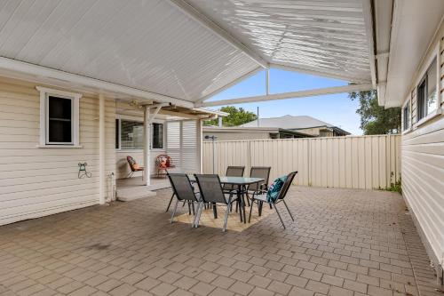 a patio with a table and chairs on it at Cute & Cuddly - Somerset Cottage in Toowoomba