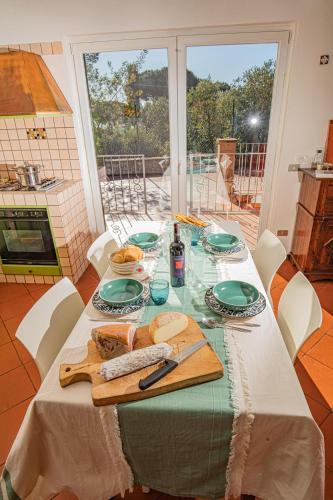a table with green plates and food on it at Affitti Brevi Toscana - La vista su Talamone in Fonteblanda