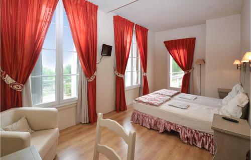 a bedroom with red curtains and a bed and a couch at Gorgeous Home In Bziers With Swimming Pool in Montblanc