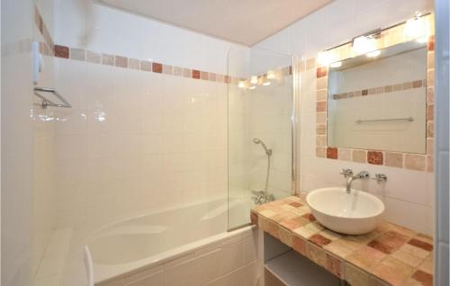 a bathroom with a sink and a tub and a mirror at Gorgeous Home In Bziers With Swimming Pool in Montblanc