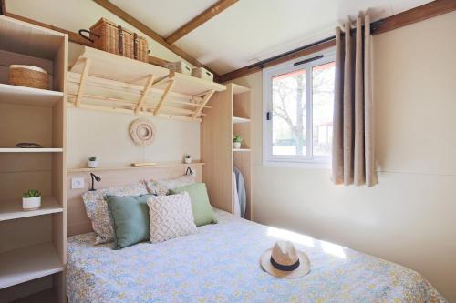 ein Schlafzimmer mit einem Bett mit Hut darauf in der Unterkunft Ushuaïa Villages La Buissonnière Lodges in Chisseaux
