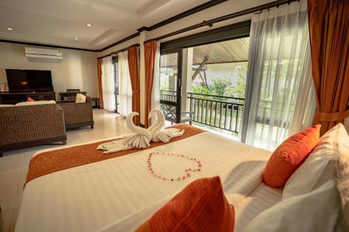 a bedroom with a bed with a heart decoration on it at Am Samui Palace in Lamai