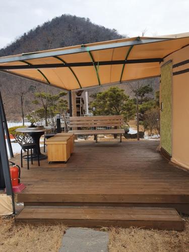 drewniany taras z ławką i stołem w obiekcie MongGo MongGo Glamping w mieście Hongcheon