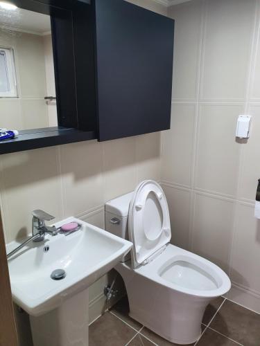 Łazienka z białą toaletą i umywalką w obiekcie MongGo MongGo Glamping w mieście Hongcheon
