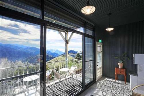 Cette chambre dispose d'un balcon avec vue sur les montagnes. dans l'établissement 阿里山-山日茶旅民宿, à Le-yeh