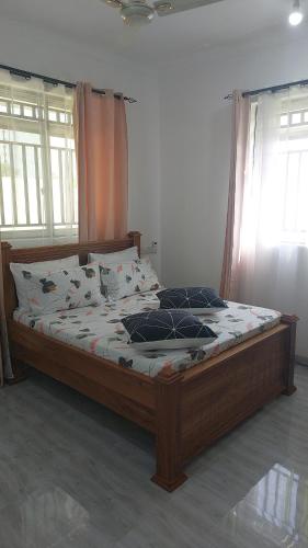 - une chambre avec un grand lit dans une pièce dotée de fenêtres dans l'établissement Nungwi appartement- house, à Nungwi