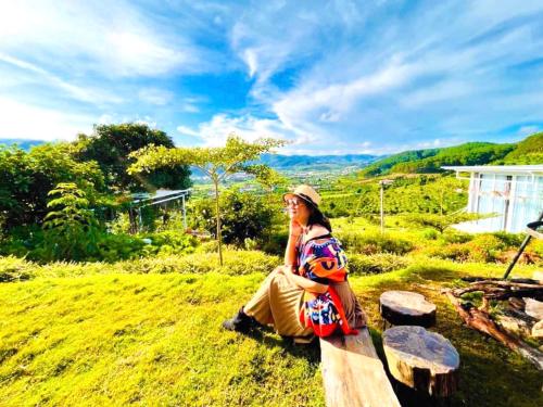 a woman sitting on a bench in the grass at Nacasoo hill in Tiên Hai