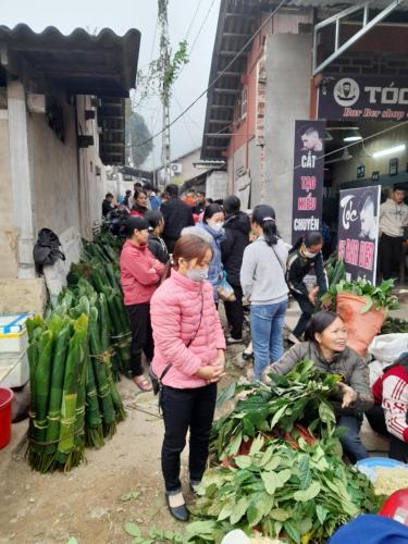 a group of people standing around a market with vegetables at Khách sạn Vườn Quốc gia Ba Bể in Bak Kan