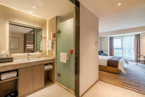 a hotel room with a bed and a bathroom at Chengdu Prolit Hotel in Chengdu