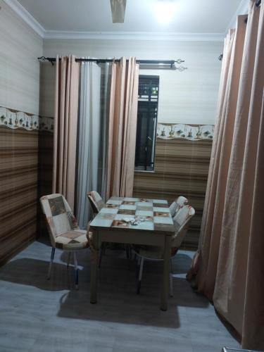 南威的住宿－Nungwi appartement- house，一间带桌子和两把椅子的用餐室