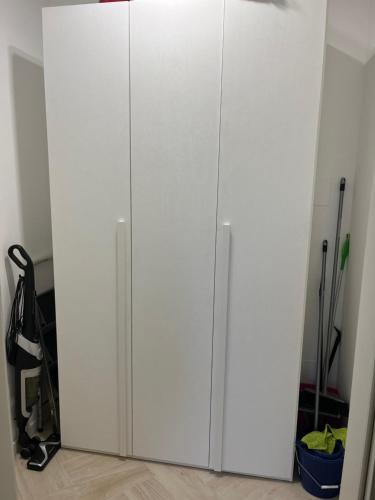 biała szafka z dwoma drzwiami w pokoju w obiekcie Monolocale Bicocca w Mediolanie