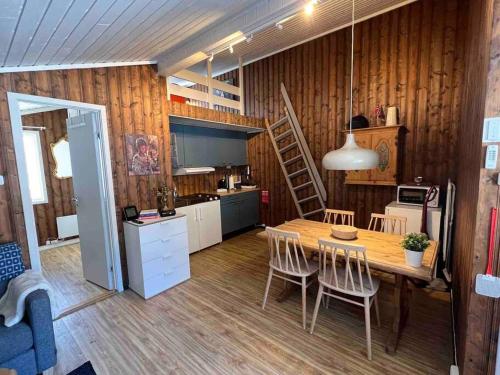 una cucina e una sala da pranzo con tavolo e sedie di Koselig hytte med uteplas ved Hallingdalselva ad Ål