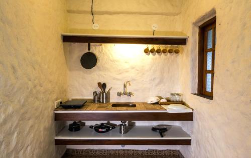 Avontade Suites في أنجونا: مطبخ صغير مع حوض ومكتب