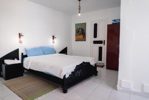 a bedroom with a large bed with blue pillows at Auberge Sable D'Or in Sidi Ifni