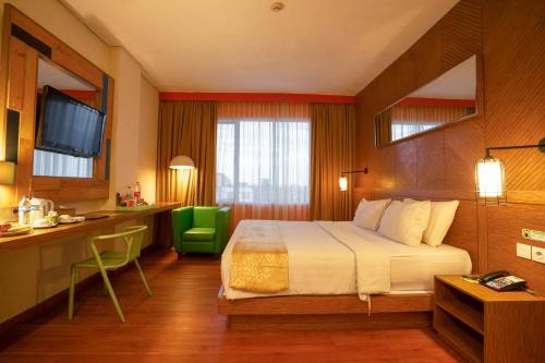 a hotel room with a bed and a desk at MaxOneHotels.com at Vivo Palembang in Palembang