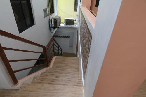 a staircase in a house with wooden floors at JM's BnB Hauz Air-conditioned private room in Kalibo