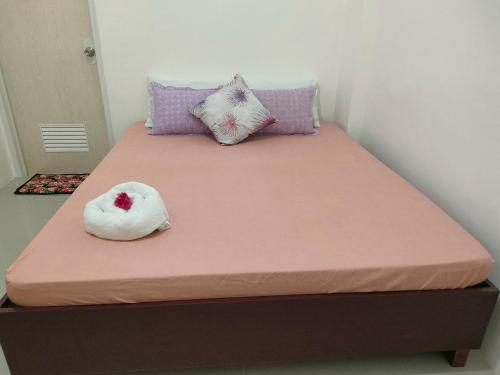 Una cama con dos animales de peluche encima. en JM's BnB Hauz Air-conditioned private room en Kalibo