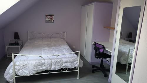 a bedroom with a bed and a desk and a mirror at serge et annick in Cérans-Foulletourte