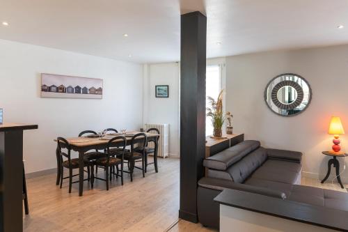 - un salon et une salle à manger avec un canapé et une table dans l'établissement Le Rooftop Briviste - 2 Chambres, à Brive-la-Gaillarde