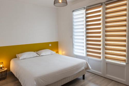 een slaapkamer met een groot wit bed en ramen bij BUGEAUD #2 - Grande Terrasse - 2 chamb in Brive-la-Gaillarde
