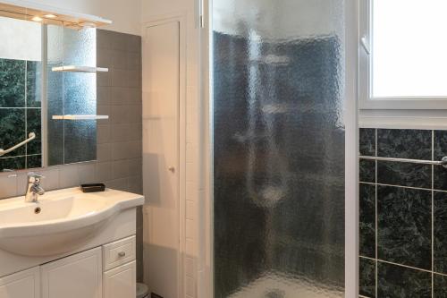 uma casa de banho com um chuveiro, um lavatório e um espelho. em BUGEAUD #2 - Grande Terrasse - 2 chamb em Brive-la-Gaillarde