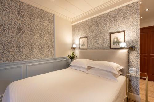 a bedroom with a white bed with blue walls at Despotiko Hotel in Mýkonos City