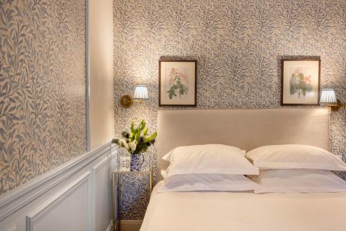 a bedroom with a bed with two pictures on the wall at Despotiko Hotel in Mýkonos City