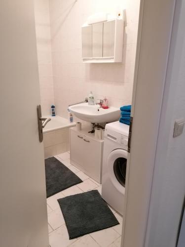 y baño blanco con lavabo y lavadora. en Monteurwohnung App 2 en Pirmasens