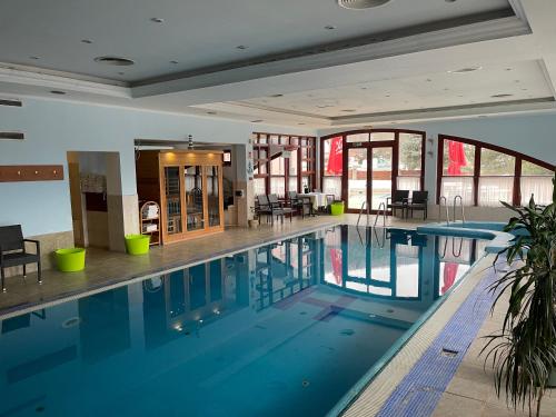 a large swimming pool in a building with windows at Hotel Hunor in Sátoraljaújhely