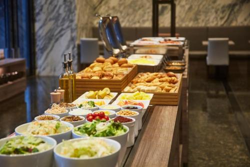 una línea de buffet con diferentes tipos de comida y repostería en Hotel Villa Fontaine Grand Tokyo-Shiodome, en Tokio