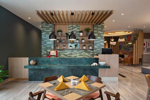 a restaurant with a table and chairs in a room at MaxOneHotels at Kota Harapan Indah-Bekasi in Bekasi