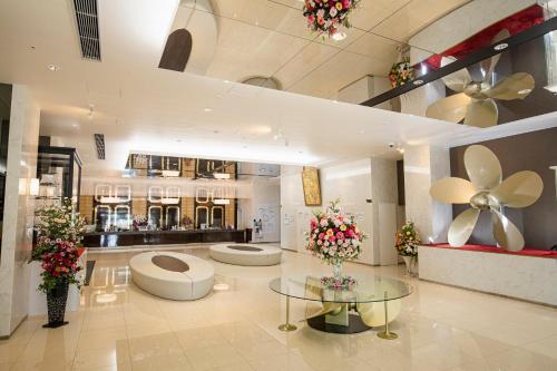een lobby met 2 toiletten en een tafel met bloemen bij Samson Hotel in Hirado