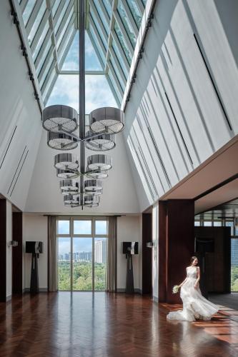 a woman in a white dress dancing in a room with windows at Andaz Shenzhen Bay Book 2 nights and above enjoy special offer in Shenzhen