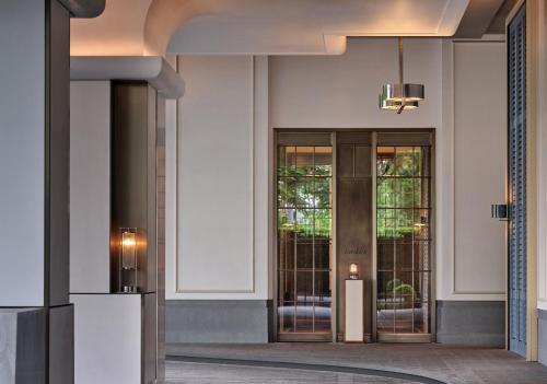 a lobby with two glass doors and a light fixture at Andaz Shenzhen Bay Book 2 nights and above enjoy special offer in Shenzhen