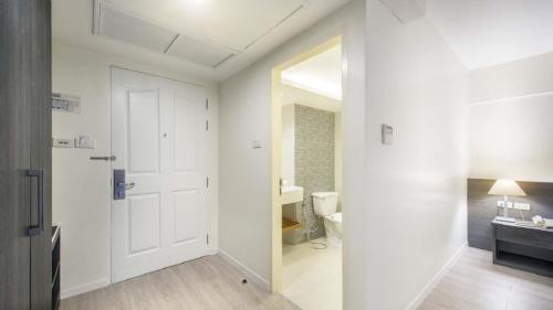a white bathroom with a toilet and a sink at Le Tada Residence in Bangkok